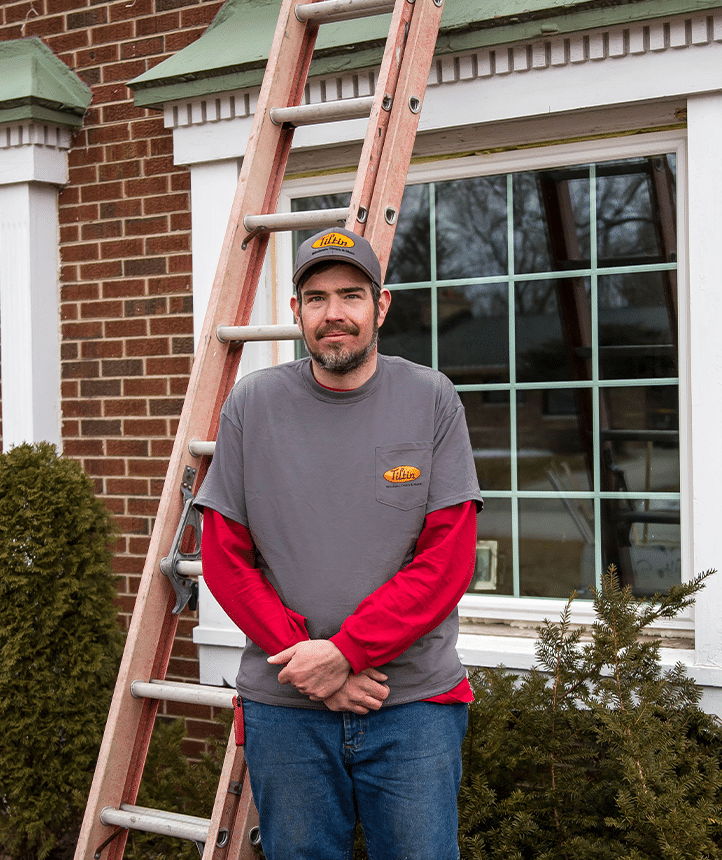 Tiltin installer standing beside a residential replacement window