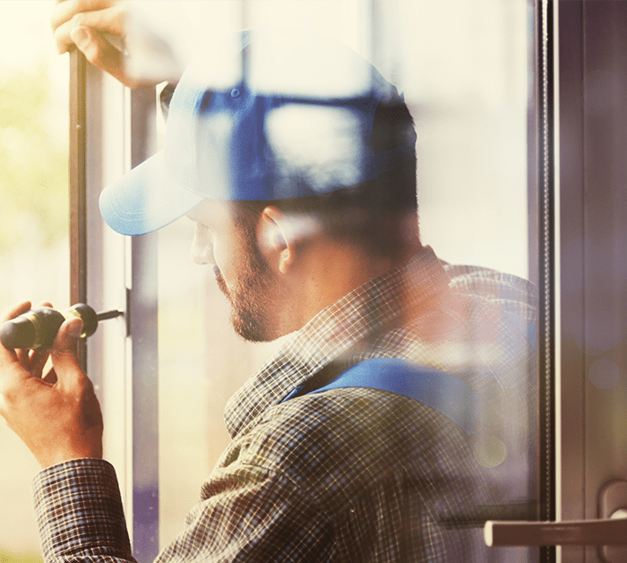 Installer fastening hardware on a residential window