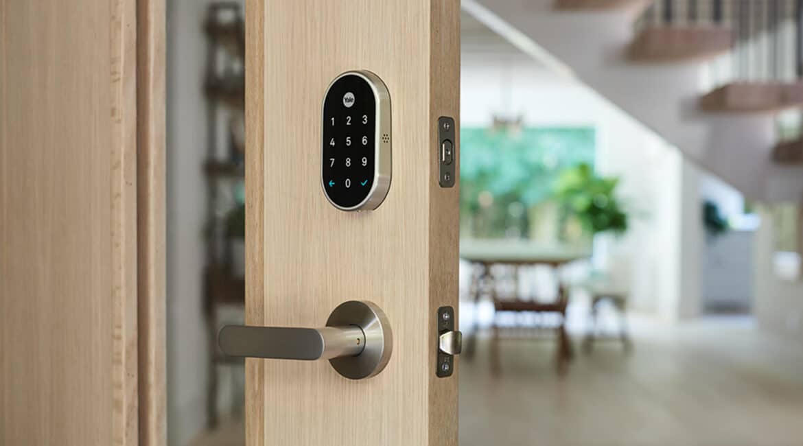 Keyless smart lock installed on a wooden front door inside a modern home.